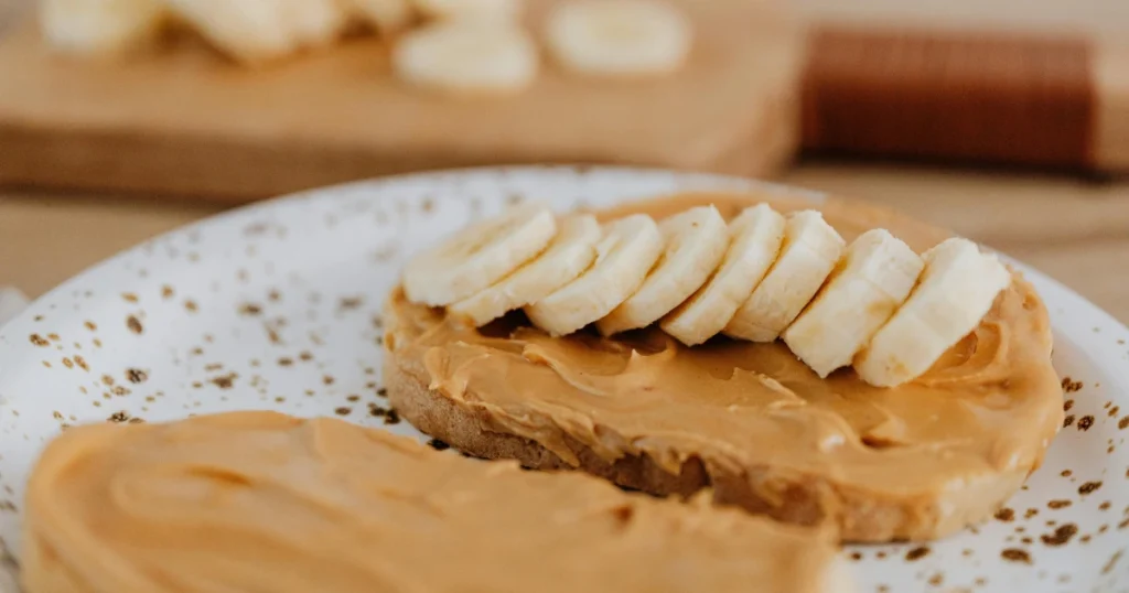 A slice of bread spread with peanut butter, a simple and protein-packed snack option